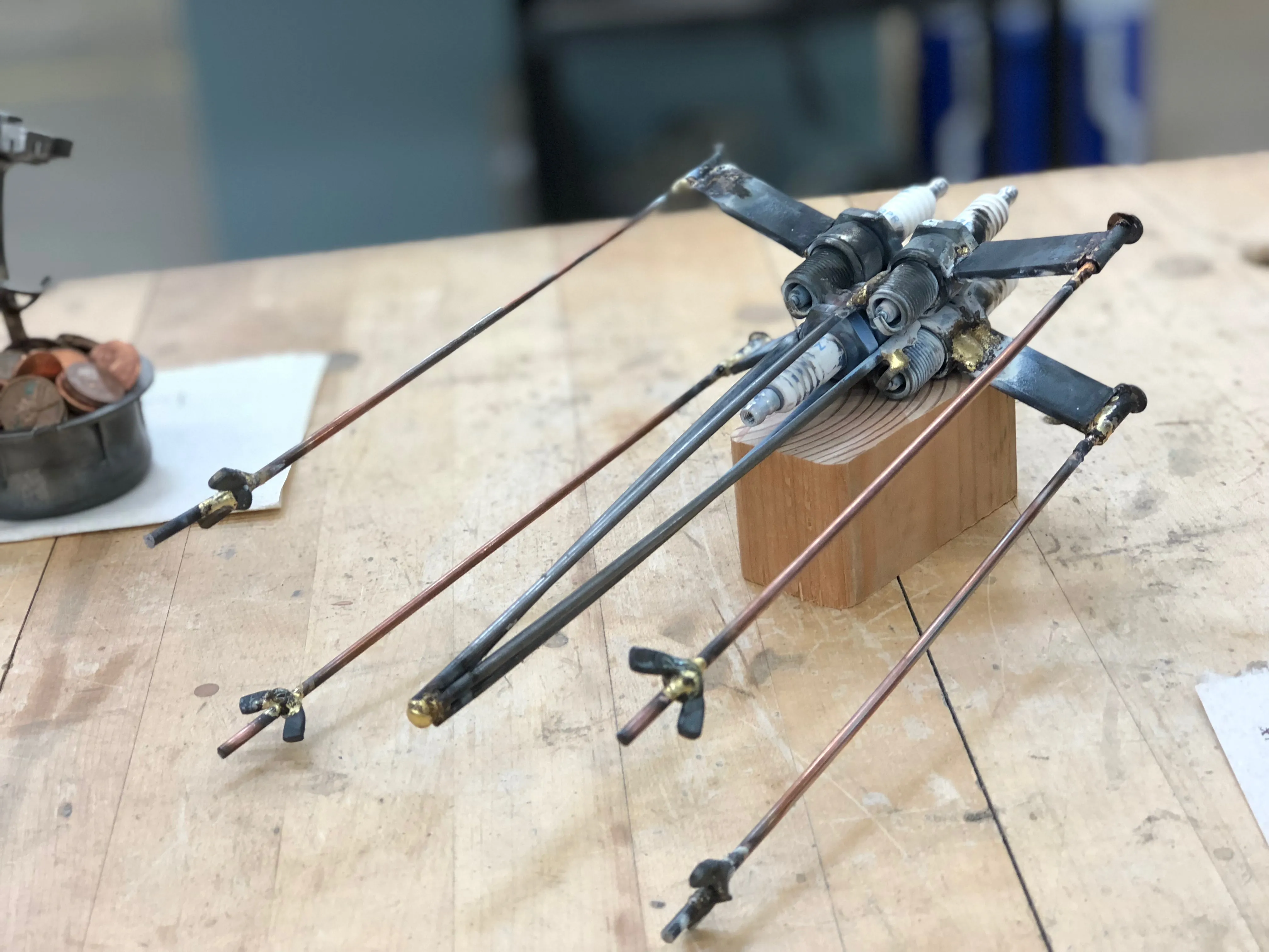 An art-metal X-wing perched atop a wood block